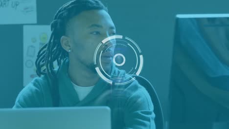 animation of scanning icon moving over african american businessman with dreadlocks using laptop