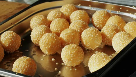 Traditional Chinese food Jian dui or sesame ball close-up. Fried Chinese pastry made from glutinous rice flour with sesame seeds. Local street food market outdoor.