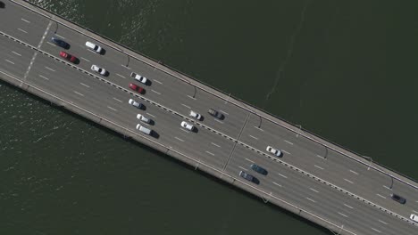 Zoom-Aéreo-En-La-Concurrida-Carretera-Del-Puente-De-La-Carretera-Directamente-Sobre-El-Puente-Del-Capitán-Cook-En-El-Agua-Oscura-Del-Océano-En-Taren-Point,-Sydney,-Australia