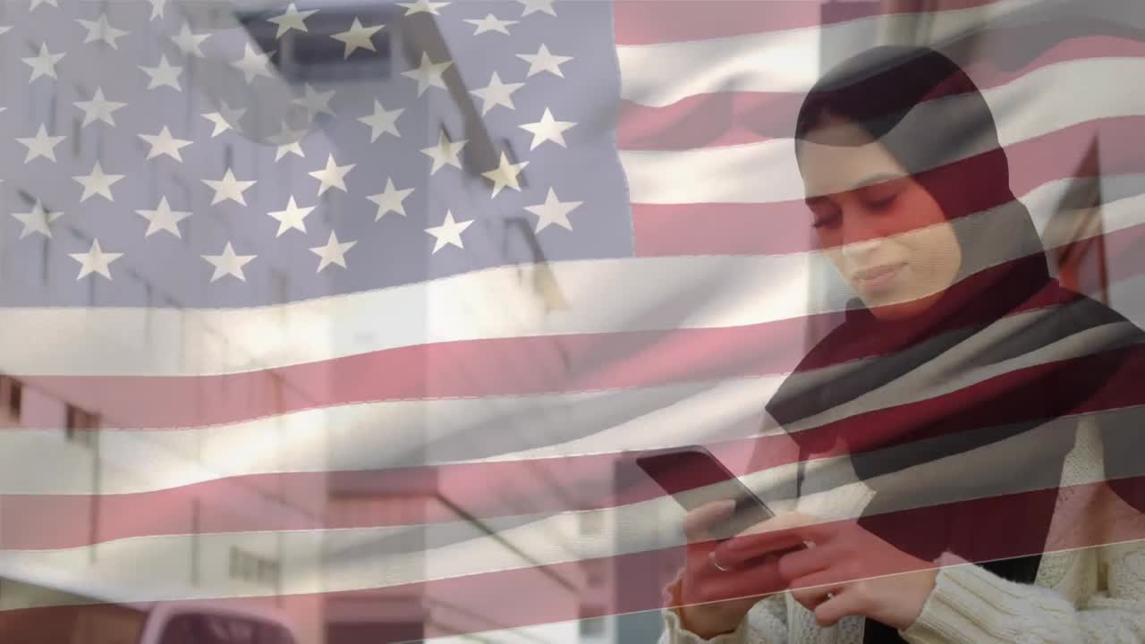 animación de la bandera estadounidense ondeando sobre una mujer de raza mixta en hijab usando un teléfono inteligente