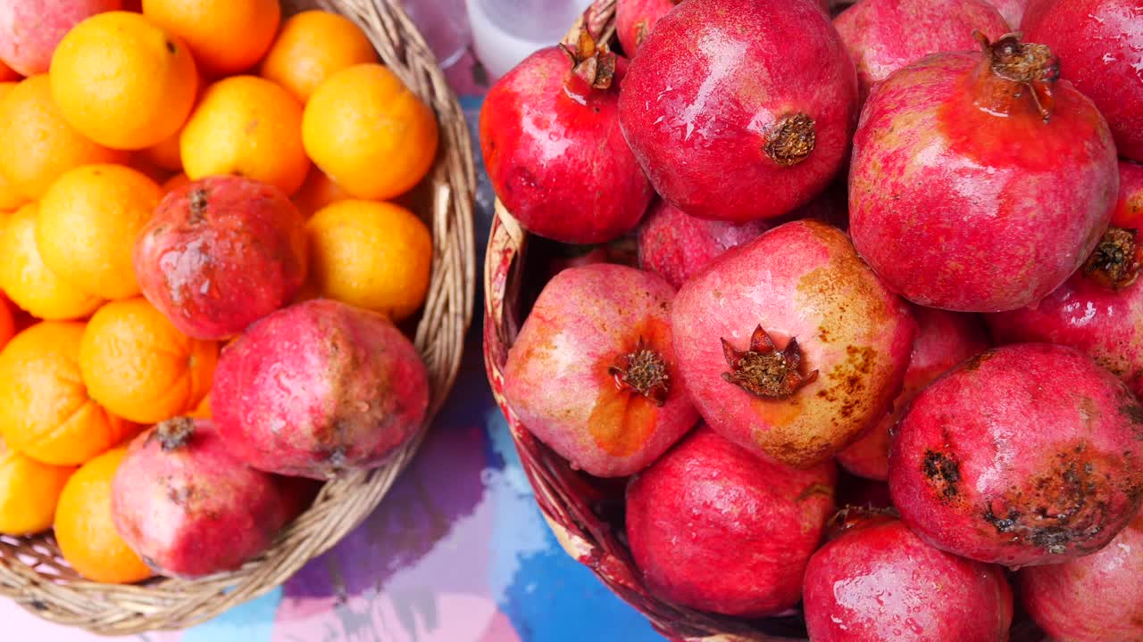 Fresh Pomegranates and Oranges in Wicker Baskets