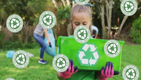 animación de iconos de reciclaje que caen sobre una niña caucásica feliz que sostiene una caja de reciclaje en el campo