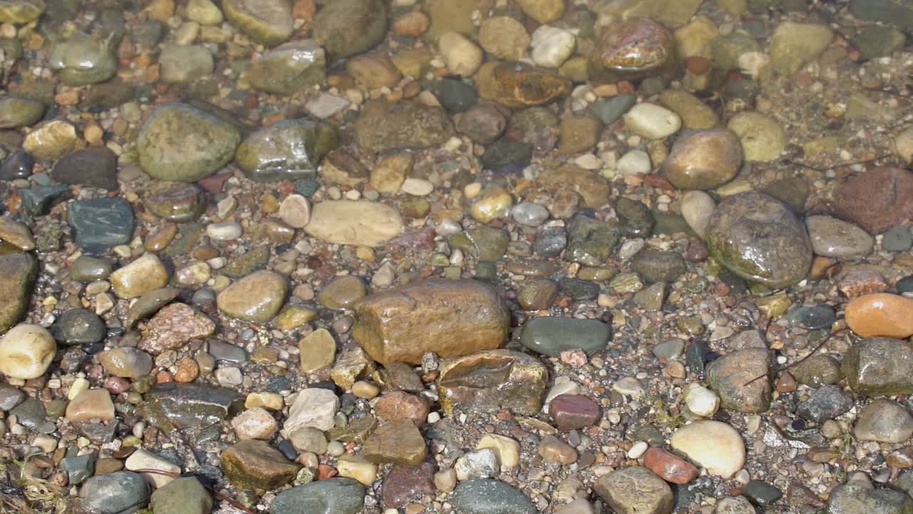 Acqua del lago che si increspa sulle rocce del fiume.