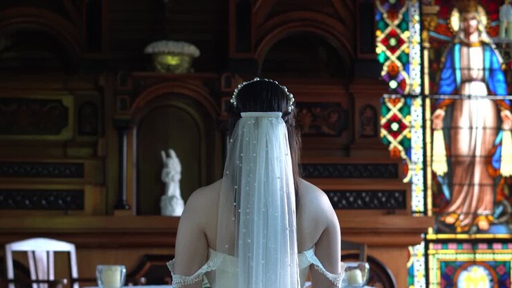 Una sposa nel giorno delle nozze, in attesa all'interno della chiesa, davanti all'altare, da sola.