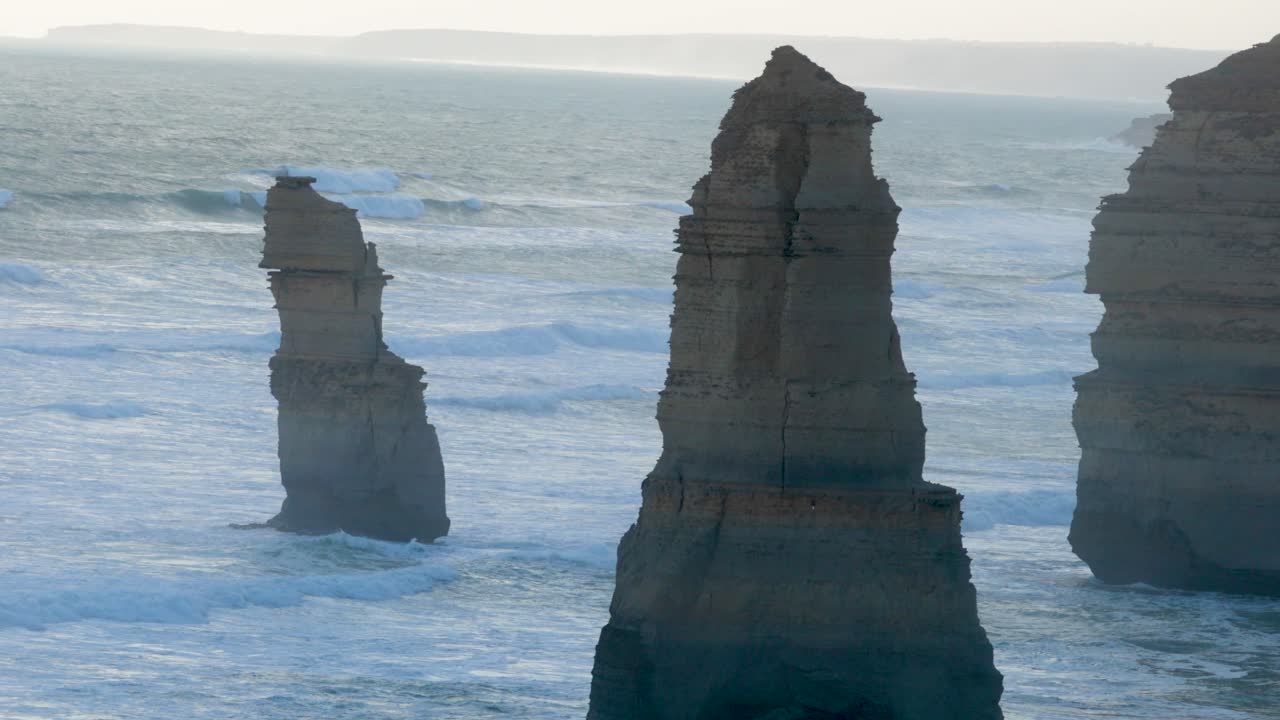A serene view of the Twelve Apostles rock formations along the Great Ocean Road, captured during a tranquil dusk setting