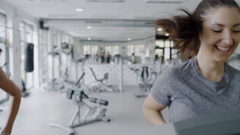 Vista-Portátil-De-Mujeres-Jóvenes-Corriendo-En-La-Cinta-De-Correr-En-El-Gimnasio