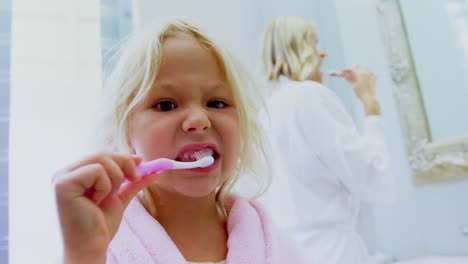 chica cepillándose los dientes en el baño 4k