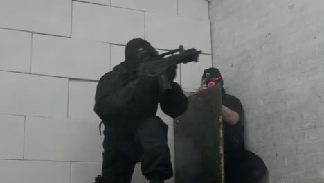 armed special forces in gas masks and balaclavas enter building through hatch in floor through a tunnel