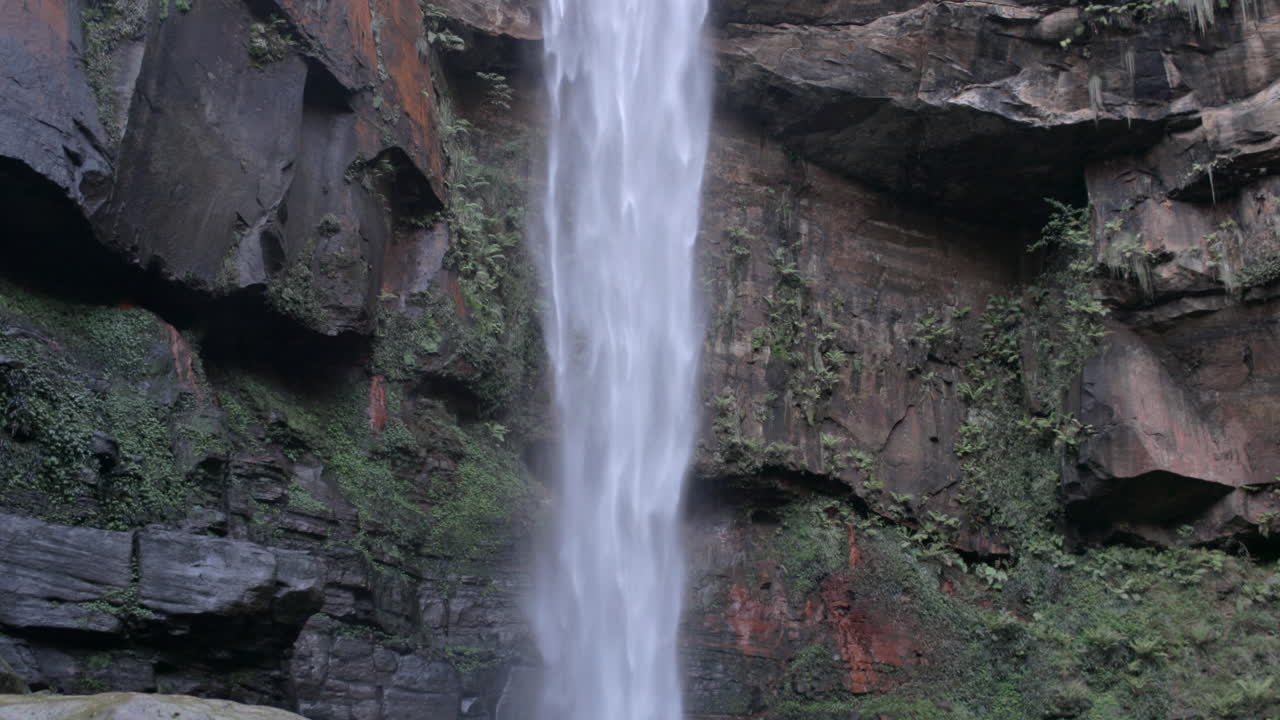 hermoso voladizo en cámara lenta de las cataratas de belmore que fluyen montaña abajo