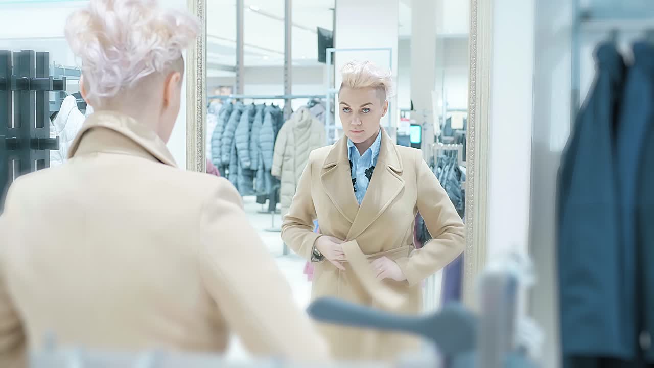 Woman Trying On a Beige Coat in a Clothing Store