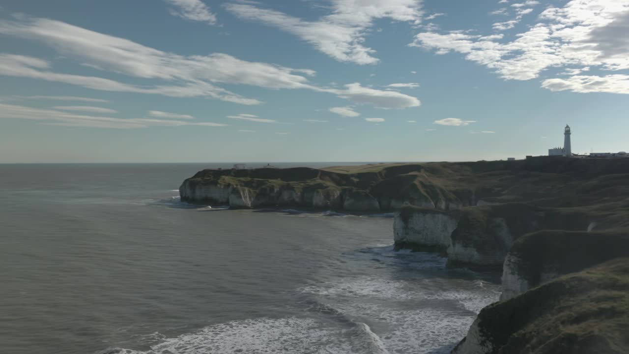 Panorering af bølger, der ruller ind på strandene ved Flamborough Head Fyr.