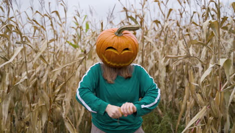 mujer enojada con cabeza de calabaza pelando y rompiendo maíz en el campo