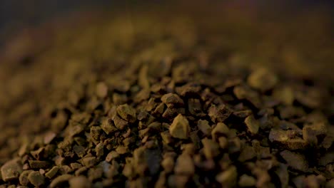 disparo macro de molidos de café que se vierte en la mesa de la cocina