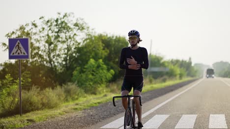 Männlicher-Radfahrer-Mit-Helm-Fährt-Fahrrad,-Streckt-Die-Hände-Aus-Und-Wärmt-Sich-Auf