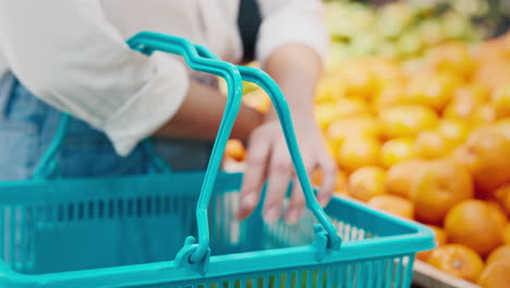 woman shopping for oranges in grocery store