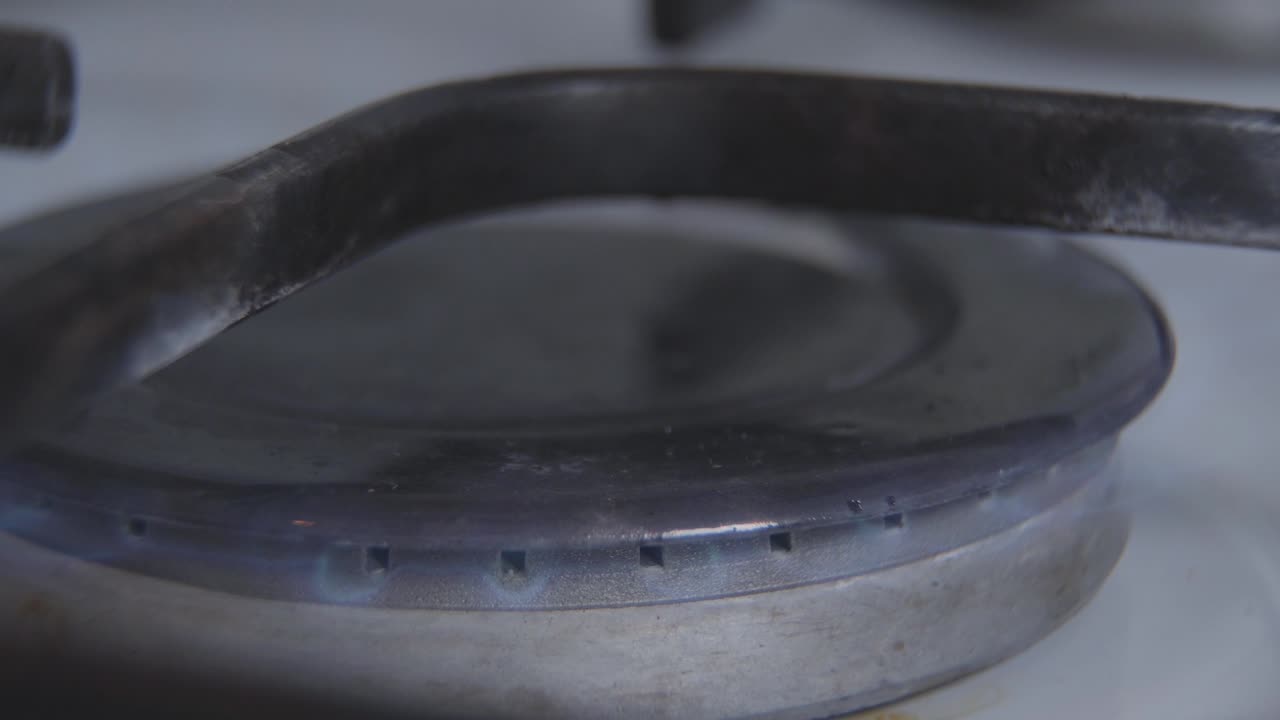 экстремальный крупный план горящей спички, зажигающей пламя на горельщике. включение бытовой газовой плиты. бытовое оборудование, топливо, кухня, приготовление пищи