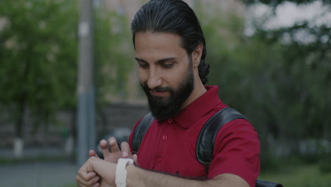 man checking smartwatch in city