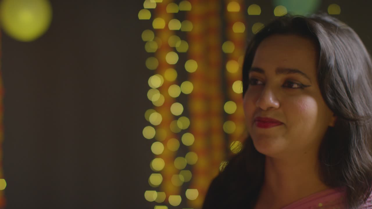 Portrait Of Laughing Asian Woman Celebrating Diwali Against Bokeh Lighting Background