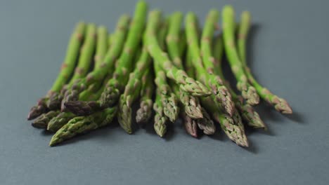 video of close up of fresh asparagus over grey background