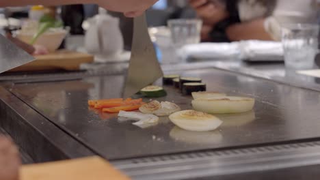 Restaurante-Teppanyaki-En-Osaka-Kobe-Japón-Chef-Preparando-Verduras-Para-Aderezar-Kobe-Wagyu-Auténtica-Carne-Japonesa