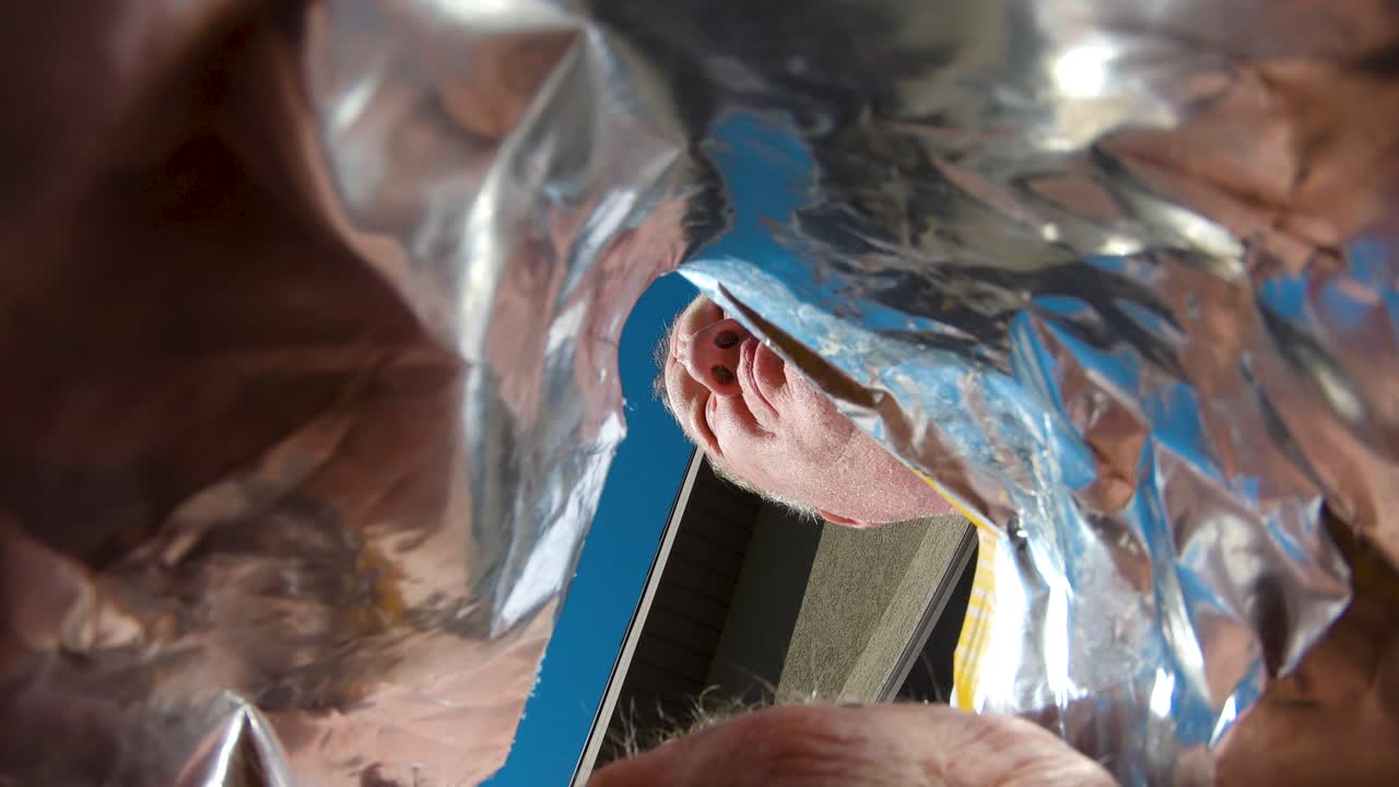 한 남자가 맛있는 음식을 먹을 때 팝콘 봉지 안에서 위를 올려다본다