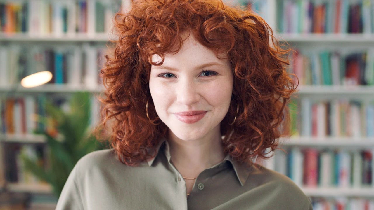 Portrait of a Young Woman with Red Curly Hair in a Library