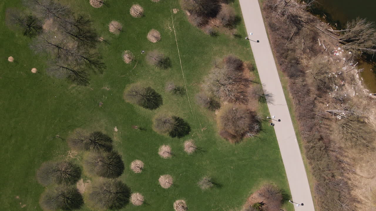 Hamilton, Ontario, Canada - A Peaceful Walking Path Winds Through Budding Trees Along the Lakefront - Vertical Shot
