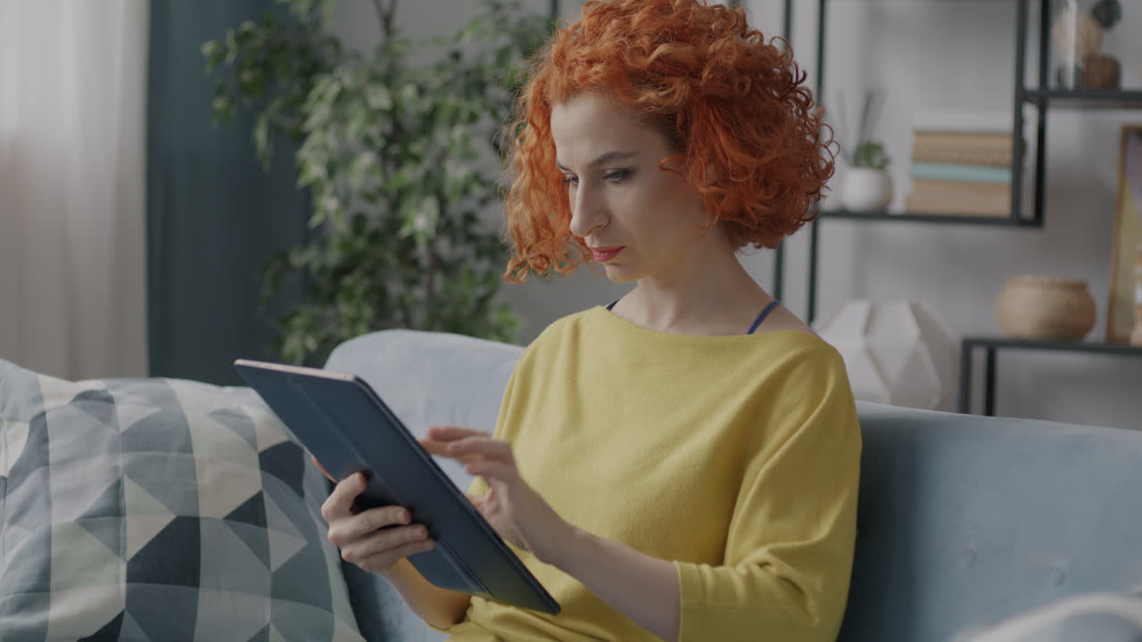 mujer usando tableta en el sofá