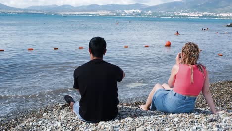 couple relaxing on a pebble beach