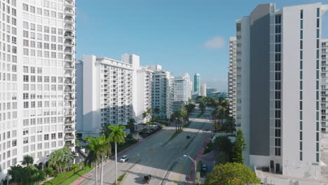 Tall-residential-buildings-or-hotels-in-modern-urban-neighbourhood.-High-rise-town-development-along-wide-trunk-road.-Miami,-USA