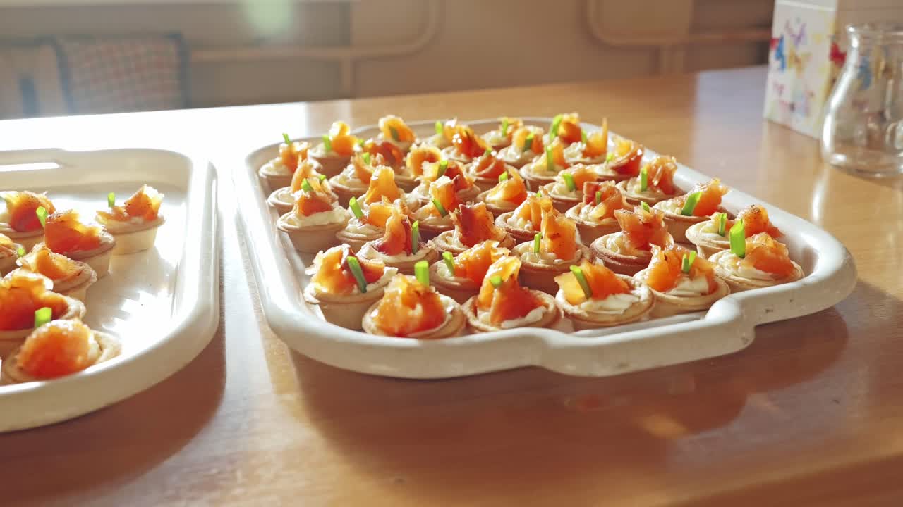 Savoureuses tartelettes au saumon avec du fromage à la crème et des herbes sur une table en bois au soleil