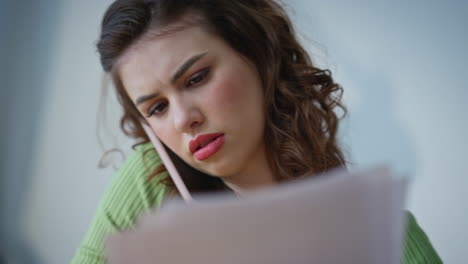 Closeup nervous manager calling mobile phone flipping papers at office table