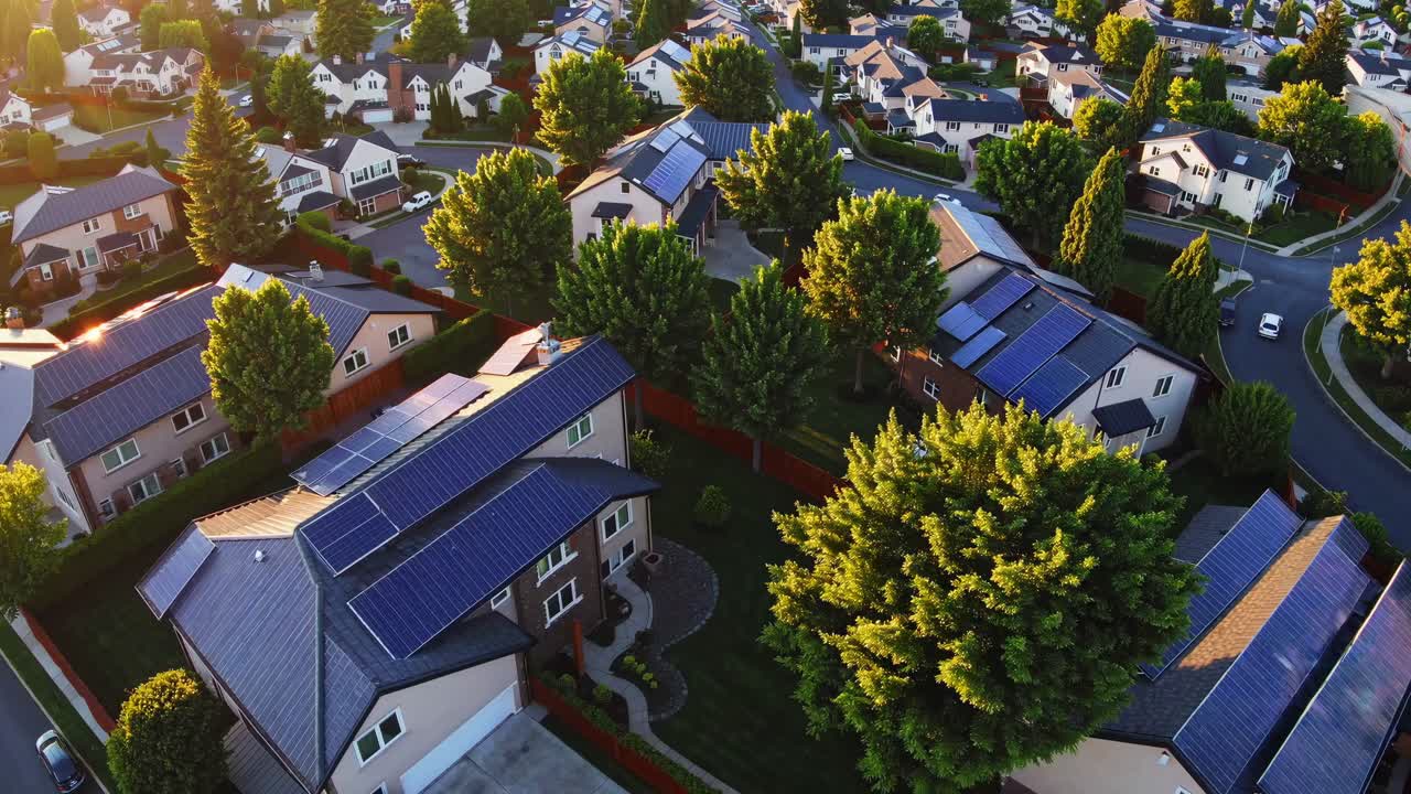 Aerial video view of suburban neighborhood with solar panels on rooftops, showcasing eco-friendly
