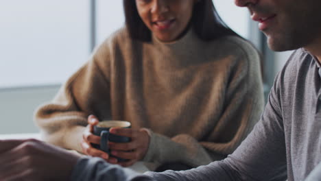 Hombre-De-Negocios-Trabajando-En-Una-Computadora-Portátil-En-El-Escritorio-Colaborando-Con-Una-Colega-Bebiendo-Café