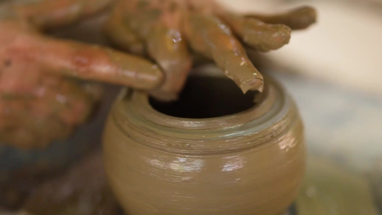 Primo piano di mani esperte che modellano un vaso di argilla bagnata su un tornio in Thailandia