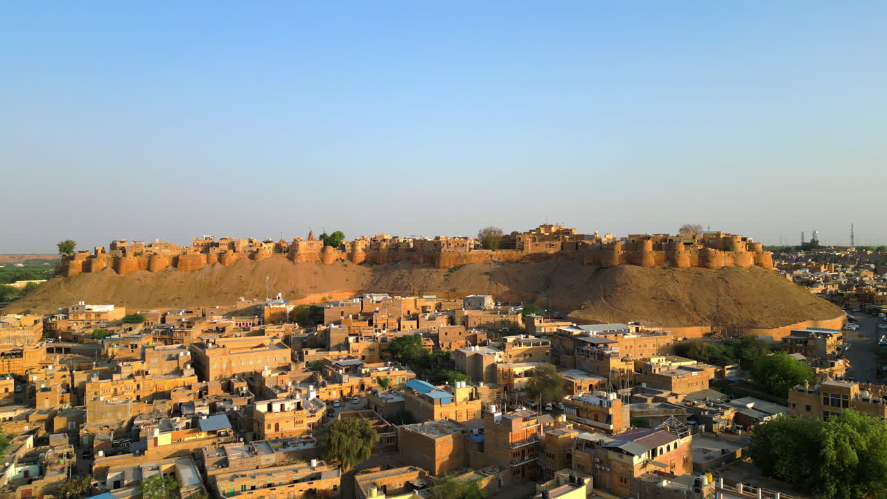 una toma de drone en órbita de 4k del fuerte de jaisalmer en rajasthan, india, que muestra su arquitectura de piedra arenisca dorada y el paisaje urbano desértico circundante en un día soleado