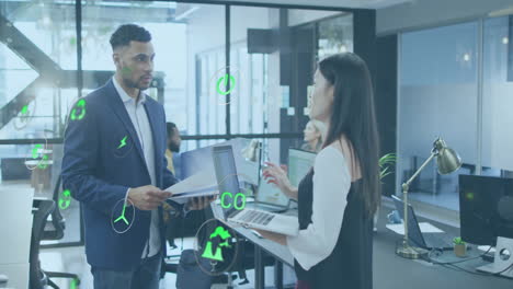 animation of multiple icons over diverse coworkers standing and discussing reports in office