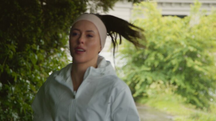 Front View Of Woman Wearing Headband Exercising Keeping Fit Running In Rain