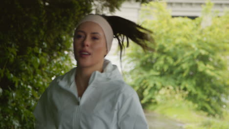 front view of woman wearing headband exercising keeping fit running in rain