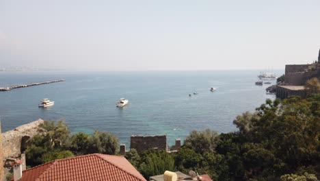 view of alanya and harbour at a sunny day. shore of mediterranean sea and historical alanya shipyard in turkey.