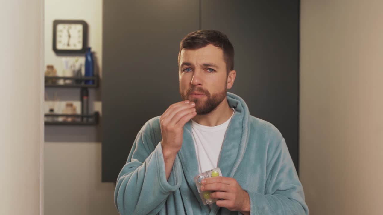 한 청년이 목이 아프다고 막대사탕 알약을 먹는다