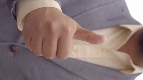 frontal close-up vertical video of man giving thumbs up in front of chest