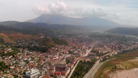 Langsamer-Flug-über-Die-Stadt-Berat-Mit-Promenade-Und-Berg-Im-Rücken