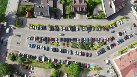 Vista-Aérea-Muy-Alta-De-Arriba-Hacia-Abajo-Del-Aparcamiento-De-La-Ciudad-Con-Muchos-Coches-Desde-Arriba-En-Un-Antiguo-Centro-De-La-Ciudad-Europea-4k