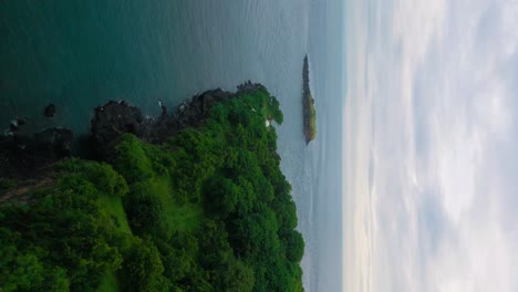 Bali-Meerblick,-Bergklippe-Am-Meeresufer-Von-Bali,-Vertikale-Antenne,-Ruhiger-Bewölkter-Himmel