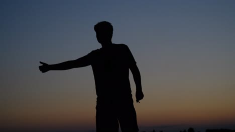 hitchhiker man sunset silhouette