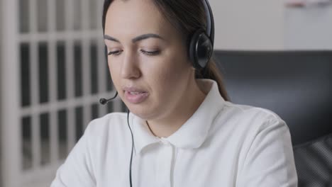 woman call centre operator, customer support agent wears headset consults client online, typing on laptop, talk in internet computer chat, helpline operator secretary make conference video call