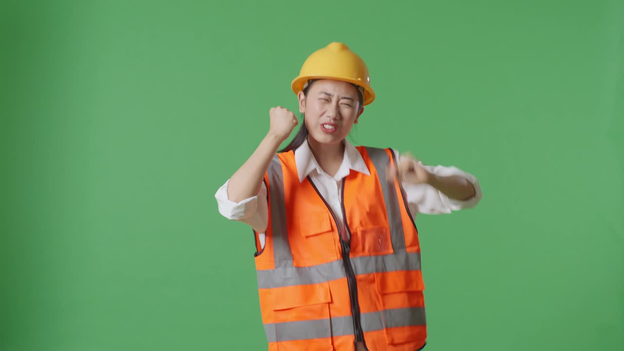 Asian Female Engineer With Safety Helmet Screaming Goal And Dancing Celebrating In The Green Screen Background Studio