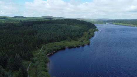 idyllic blue water reservoir lake woodland hiking walk aerial slow descending view