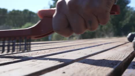 wooden deck being brushed with metal brush